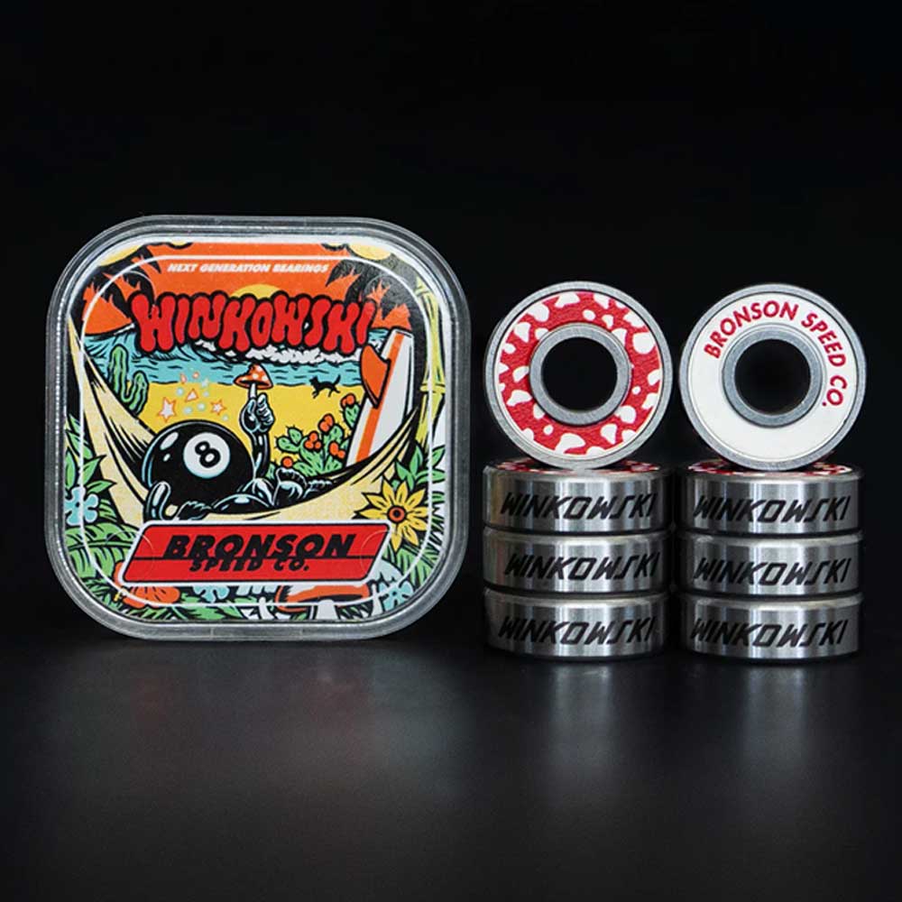 A tin with colorful “HINOKINSKI BRONSON” artwork sits beside seven stacked Bronson Speed Co. Skateboard Bearings Erick Winkowski Pro G3 and two upright bearings, one showing the BRONSON SPEED CO. logo on its red shield.