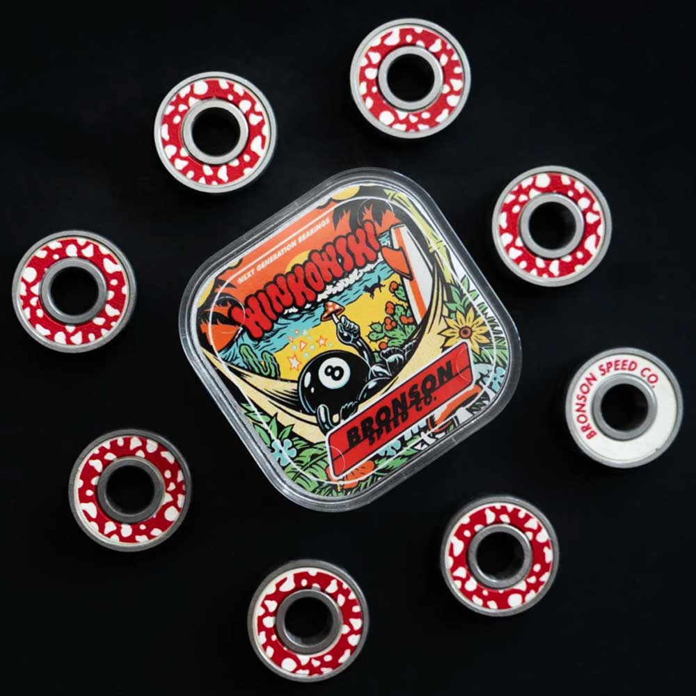 A set of eight Bronson Speed Co. Skateboard Bearings Erick Winkowski Pro G3 in red and white are displayed around a square tin with colorful artwork, cartoon character, and Krooked, Bronson, and Erick Winkowski Pro text on a black background.