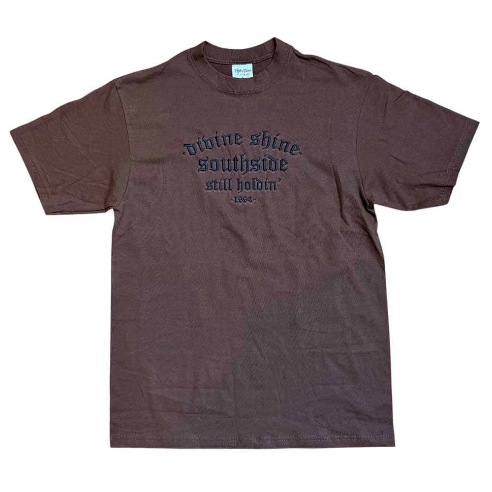 The Brown Divine Shine x Southside Still Holdin Max Heavyweight Tee features black front text honoring Southside Skatepark. Perfect for streetwear, this embroidered shirt is shown laid flat on a white background.