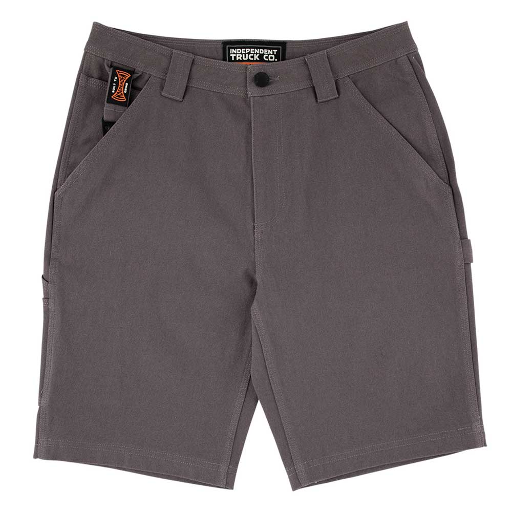 The Built to Grind Utility Shorts Pewter by Independent feature belt loops, front and side pockets, a button closure, a black Independent Trucks label above the zipper, and a black and orange "Built To Grind" tag on the waistband near a front pocket.