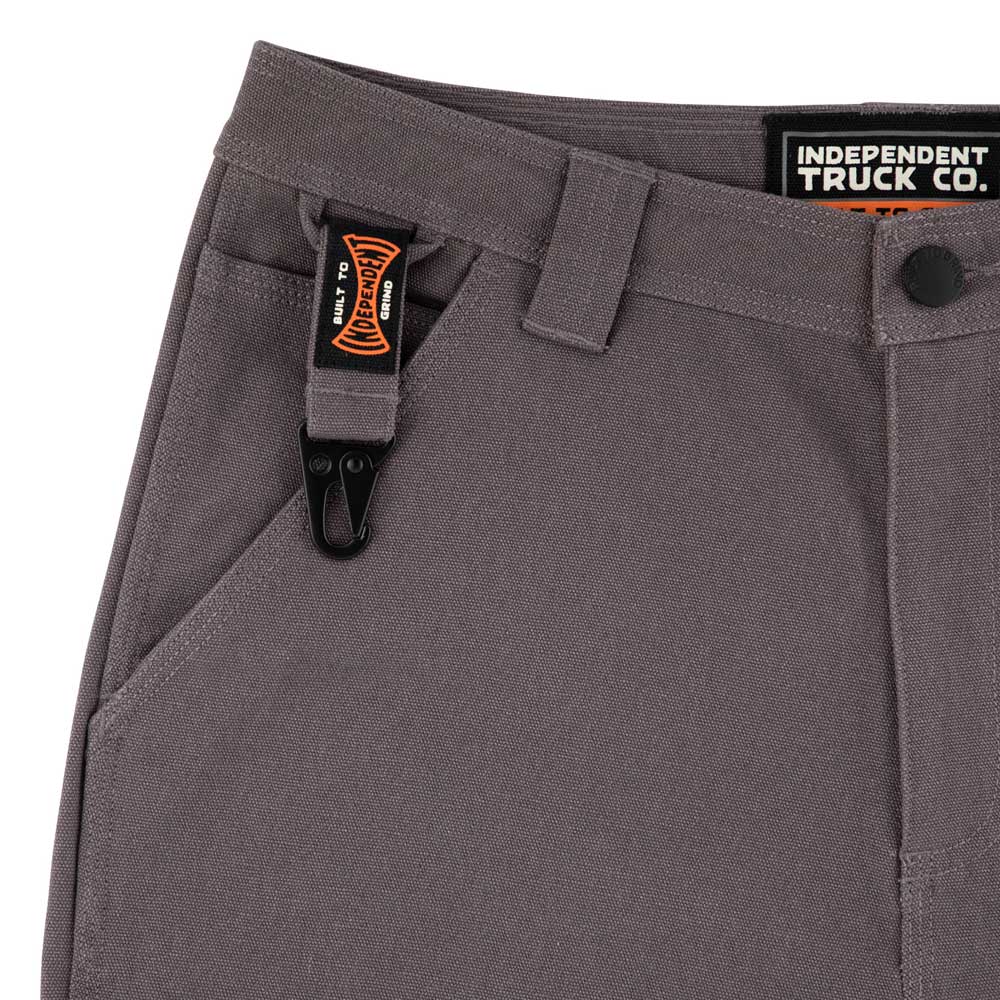 Close-up of Built to Grind Utility Shorts Pewter Bottom by Independent, showing a black and orange clip on the belt loop and a visible INDEPENDENT TRUCK CO. label on the waistband, emphasizing durable men's utility design.