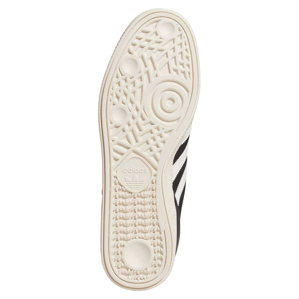 The image displays the sole of the Busenitz Black White HQ4708 Adidas Skateboarding Suede Shoes, featuring a textured off-white bottom with circular grips and the Adidas logo; part of the black and white suede upper is also visible.