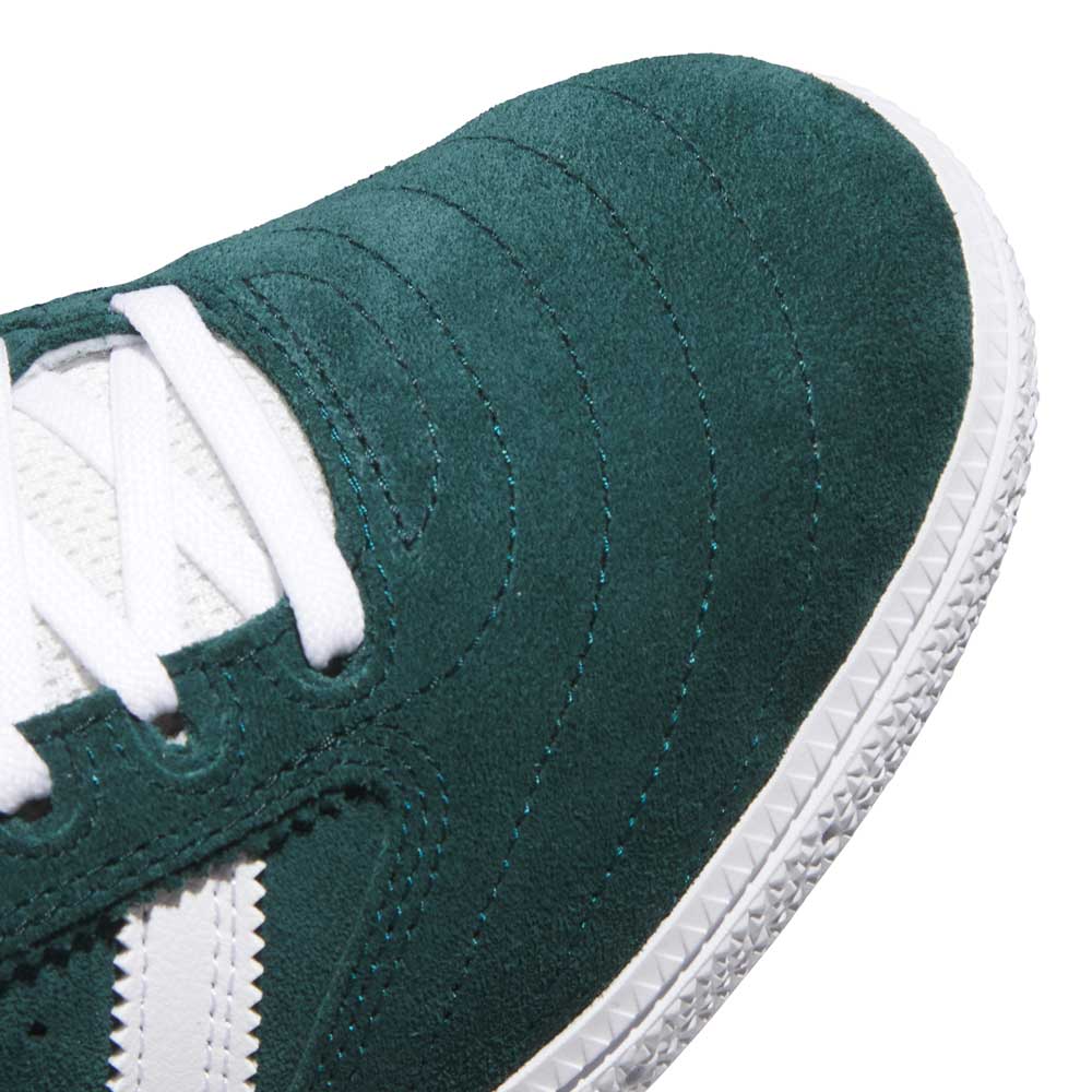 Close-up of the toe and side of the green and white Busenitz HQ7534 Adidas Skateboarding suede shoes, featuring white stitching, laces, and a textured white rubber sole.