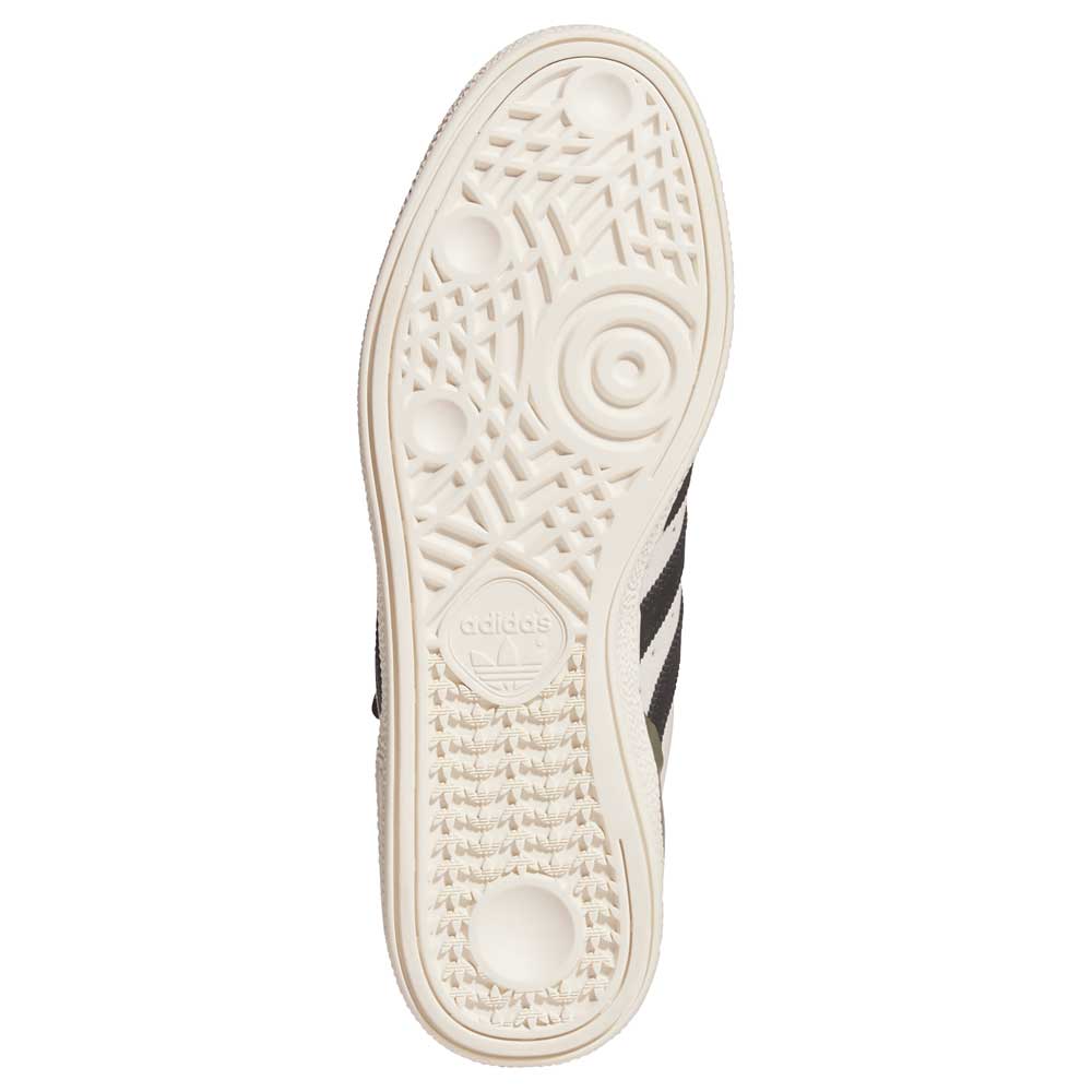 The image shows the sole of the Busenitz Tan White Black HQ4746 Adidas Skateboarding Suede Shoes, with a textured rubber pattern and Adidas logo. The light sole contrasts with part of the black durable suede upper along the sides.