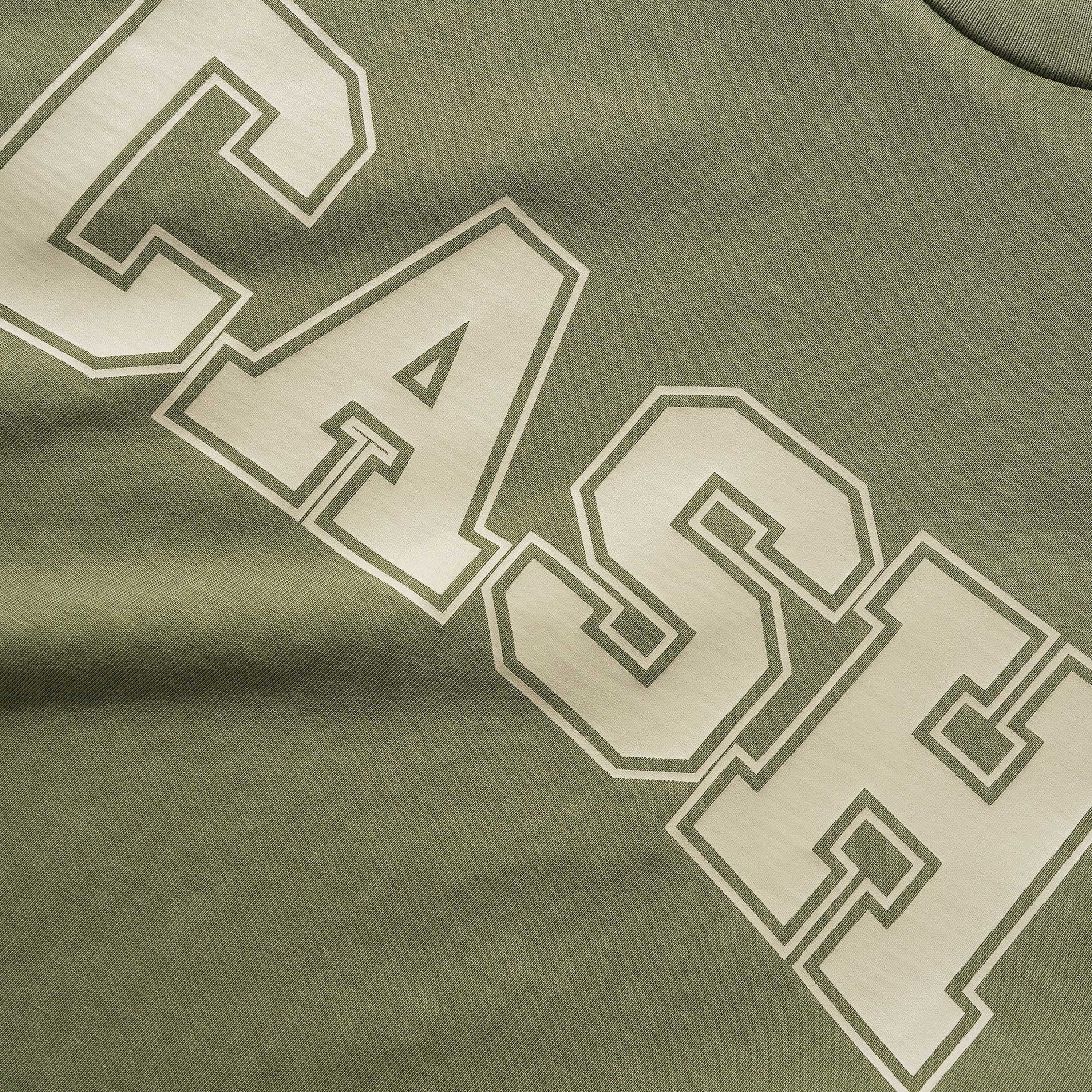 A close-up of the Campus Tee Olive Cash Only, a heavyweight cotton tee in olive green (6.5oz fabric), featuring "CASH" in bold, white outlined block letters screenprinted across the chest.