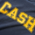 The Campus Tee Washed Navy Cash Only is a navy blue heavyweight cotton t-shirt featuring "CASH" in large, bold yellow block letters outlined in gold across the front.