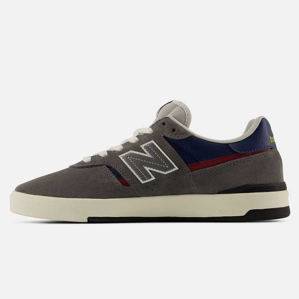 A side view of the Castlerock Navy Jamie Foy Cup 306 CYZ New Balance Numeric Suede Skateboarding Shoe, featuring a durable gray suede upper, white sole, navy and red accents, and a white "N" logo on the side, displayed against a plain white background.