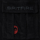 Close-up of the Classic 87 Corduroy Cargo Pant Black Spitfire Wheels: features a black corduroy cargo pocket with gray "SPITFIRE" embroidery on the flap and a red embroidered cartoon flame face below, channeling Spitfire Wheels' iconic style.