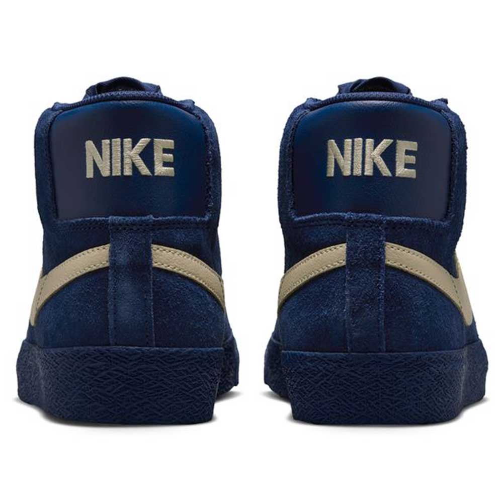 A pair of Coastal Blue Pale Yellow IO0667400 Blazer Mid Nike SB suede skateboarding shoes seen from the back, featuring pale yellow swooshes and NIKE in bold white on the heel tabs, designed for responsive cushioning and all-day comfort.