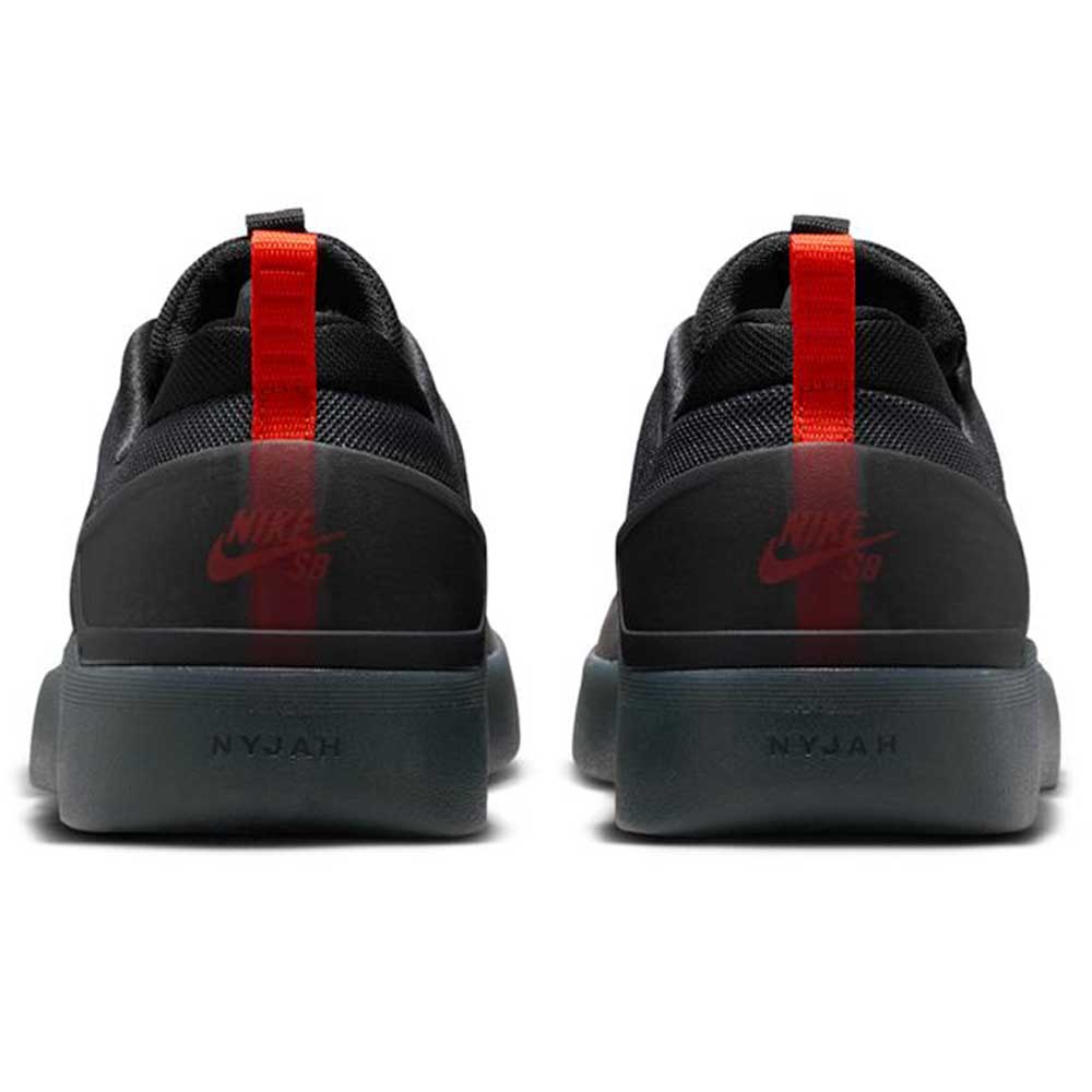 A pair of Cool Grey White FQ1273003 Zoom Nyjah 4 Nike SB skateboarding shoes viewed from the back, with a red heel stripe, NYJAH on the gray sole, reinforced mesh upper, and visible Nike Swoosh and SB logos on the heel tabs.