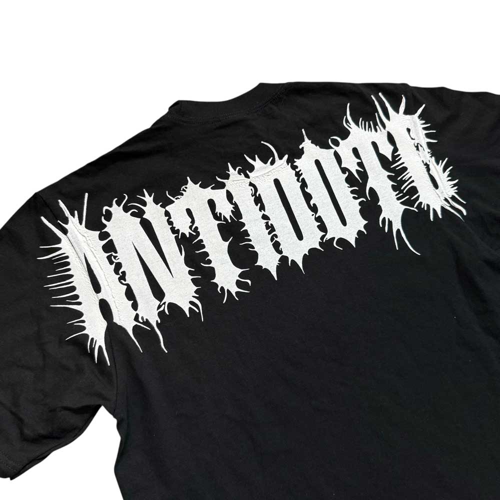 The Cropped White Shoulder Antidote Black Tee is an oversized black shirt made from 100% USA cotton, with bold, spiky "ANTISOCIAL" lettering in white across the back for a standout streetwear look.
