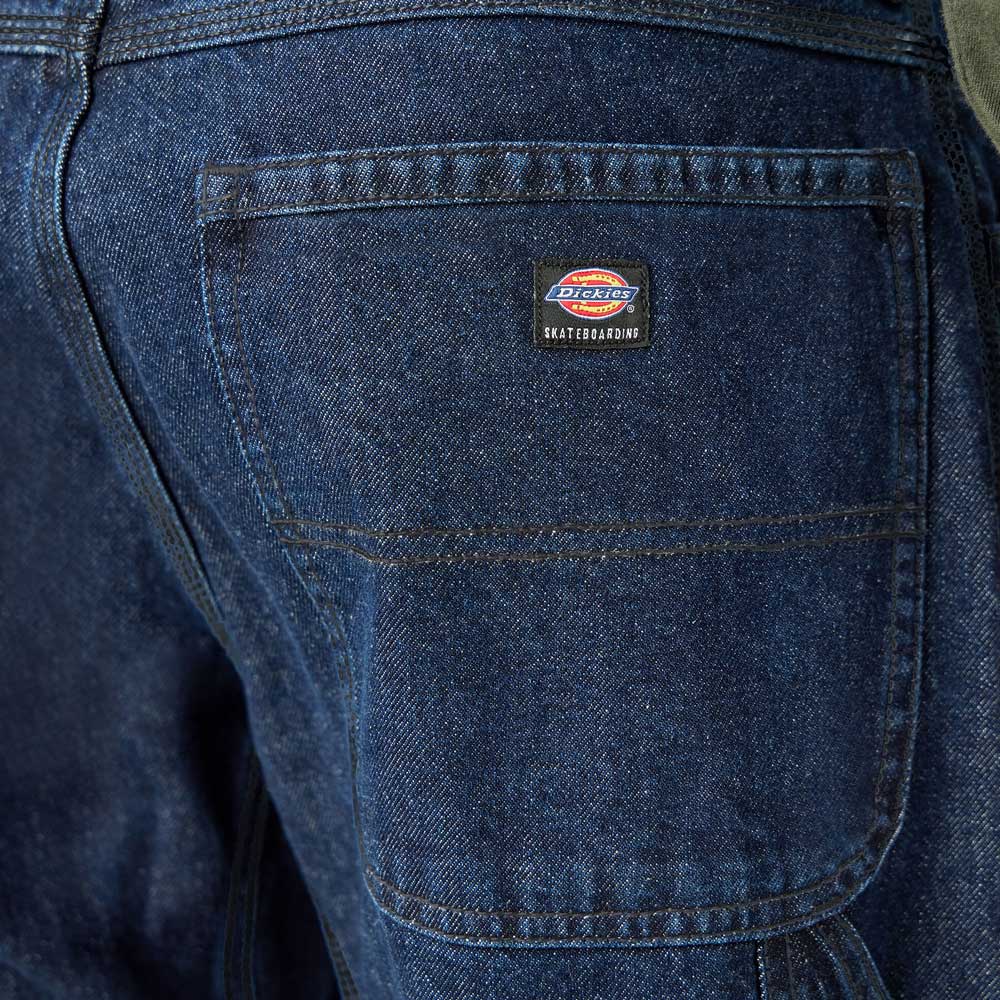 Close-up of the back pocket on DDSK68 Loose Fit Denim Pant Carpenter Dark Wash Dickies Skateboarding jeans, featuring a small rectangular Dickies patch and visible stitching details.