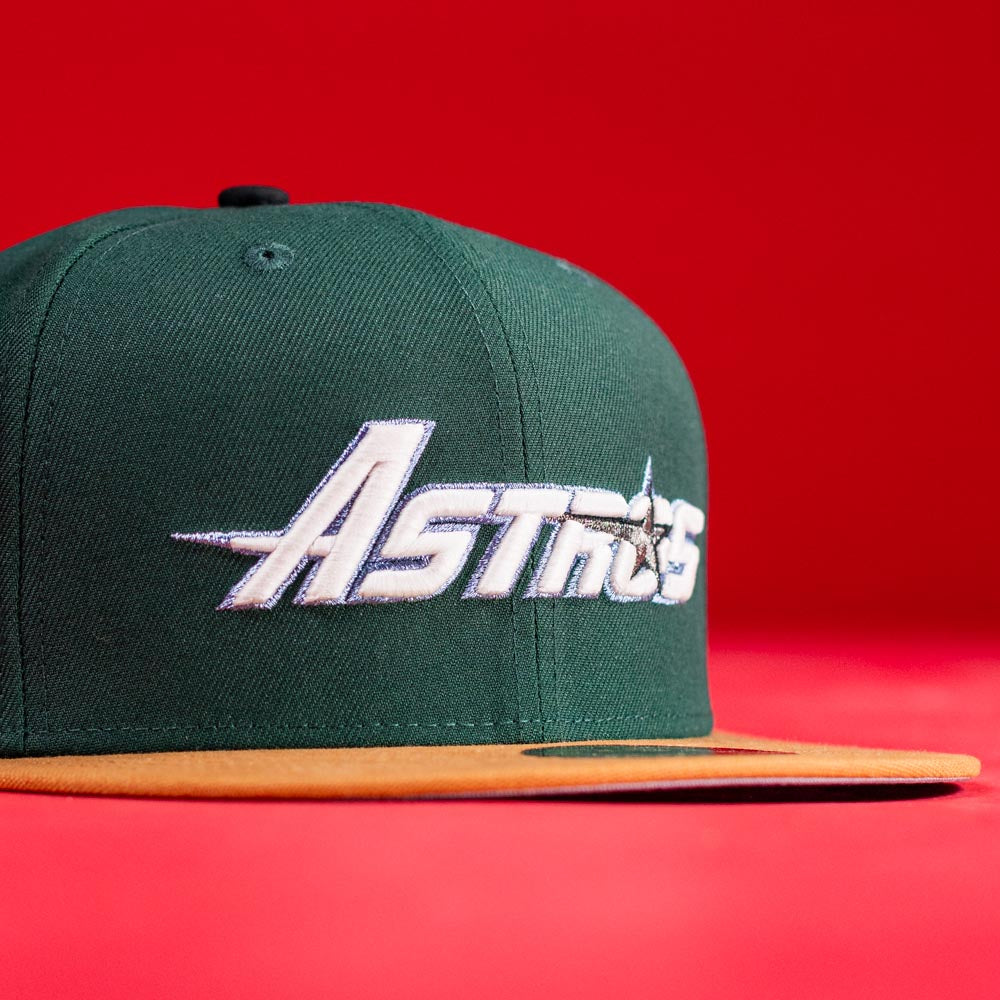 The El Tuga Houston Astros New Era Hat 5950 Fitted is a green cap with "Astros" embroidered in white, a gold star on the front, a gold brim, and a bright red background.