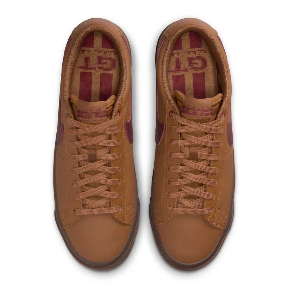 The DV1226200 GT Dark Red Brown Blazer Low Nike SB Suede Skateboarding Shoes feature a rich brown upper, tan laces, maroon accents, and bold maroon stripes and lettering on the insoles—classic skate style with standout details.