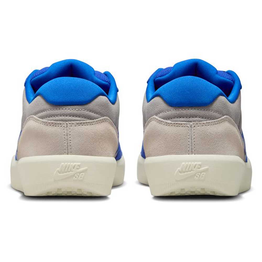 A pair of DV5477011 College Grey Racer Blue Light Orewood Force 58 Nike SB suede skateboarding shoes, seen from the back, with light gray uppers, blue lining, off-white soles, and embossed Nike SB logo on the heels.