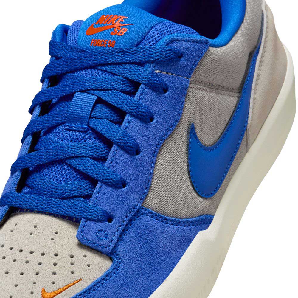 Close-up of the Nike SB Force 58 "College Grey/Racer Blue/Light Orewood" skateboarding shoe, featuring blue suede overlays, blue laces and Swoosh, a light grey perforated toe box, and orange Nike SB branding for classic hoops-inspired style.