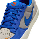 Close-up of the Nike SB Force 58 "College Grey/Racer Blue/Light Orewood" skateboarding shoe, featuring blue suede overlays, blue laces and Swoosh, a light grey perforated toe box, and orange Nike SB branding for classic hoops-inspired style.