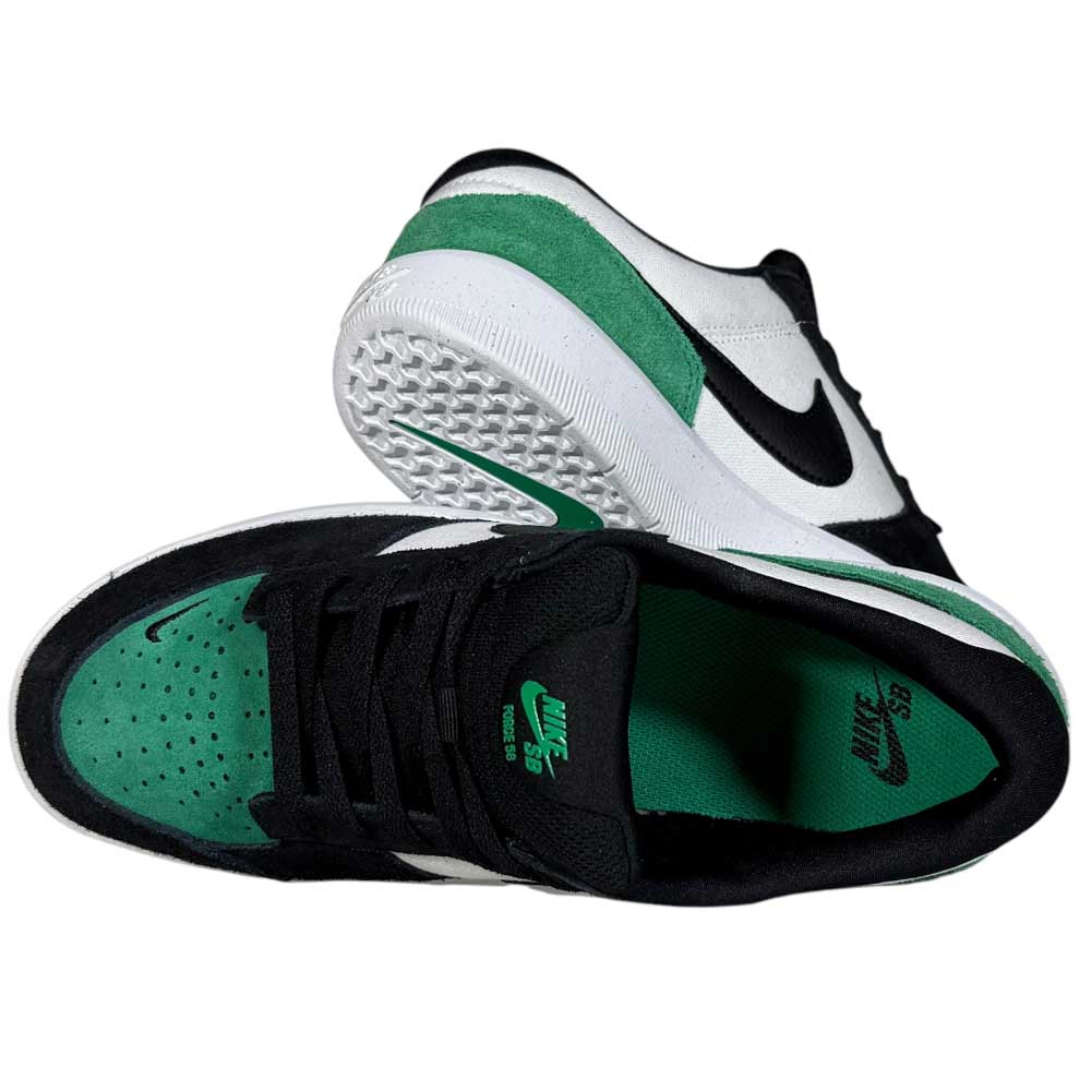 A pair of DV5477101 White Black Stadium Green Force 58 Nike SB suede skateboarding shoes is shown: one upright to highlight the cupsole and side, and the other lying down to display the green insole and black laces.