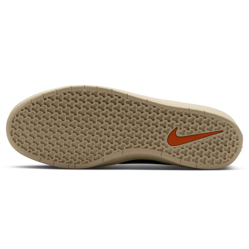The image shows the sole of the DV5477-201 Baroque Brown Mosswood Brown Force 58 Nike SB suede skateboarding shoe, featuring a beige rubber surface with a hexagonal pattern and an orange Swoosh logo near the heel, highlighting its basketball-inspired design.