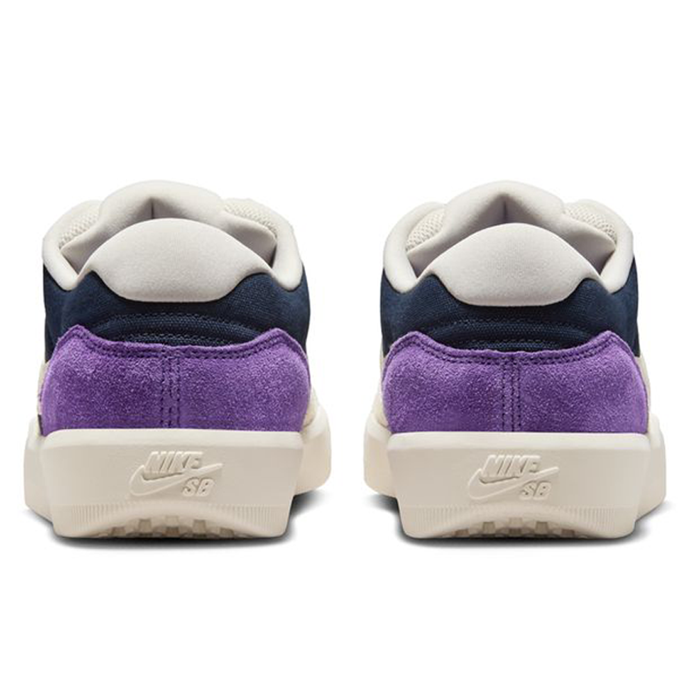 Rear view of DV5477403 Obsidian Light Orewood Brn Force 58 Nike SB suede skateboarding shoes, featuring off-white soles and heels, navy blue uppers, white collars, and bright purple suede around the lower heels. Nike SB logo embossed on each heel.