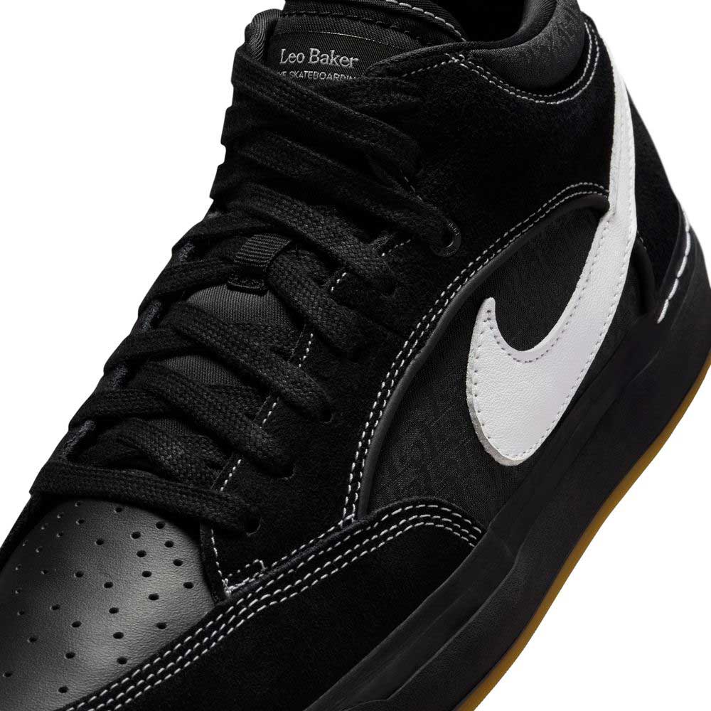 A close-up of the DX4361005 Black Gum Leo Baker React Nike SB Suede Leather Skateboarding Shoe with a white swoosh, black laces, Leo Baker text on the tongue, and a durable black sole with a light brown rubber bottom.