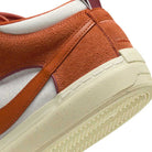 Close-up of the heel on the DX4361-202 Dark Rust White React Leo Nike SB suede & leather skateboarding shoes, showing textured cream sole, white midsection, and side stripe from Leo Baker's collaboration.