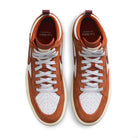 Top view of DX4361-202 Dark Rust White React Leo Nike SB skateboarding shoes, featuring burnt orange suede/leather overlays, white perforated toe boxes and laces, brown accents, and Leo Baker collaboration branding on burgundy insoles.