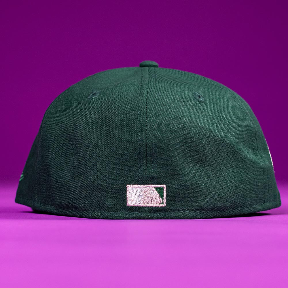 The Merc Green Silver 35th Houston Astros New Era Hat 5950 Fitted is displayed from the back on a purple background, featuring a small white rectangular logo near the bottom center.