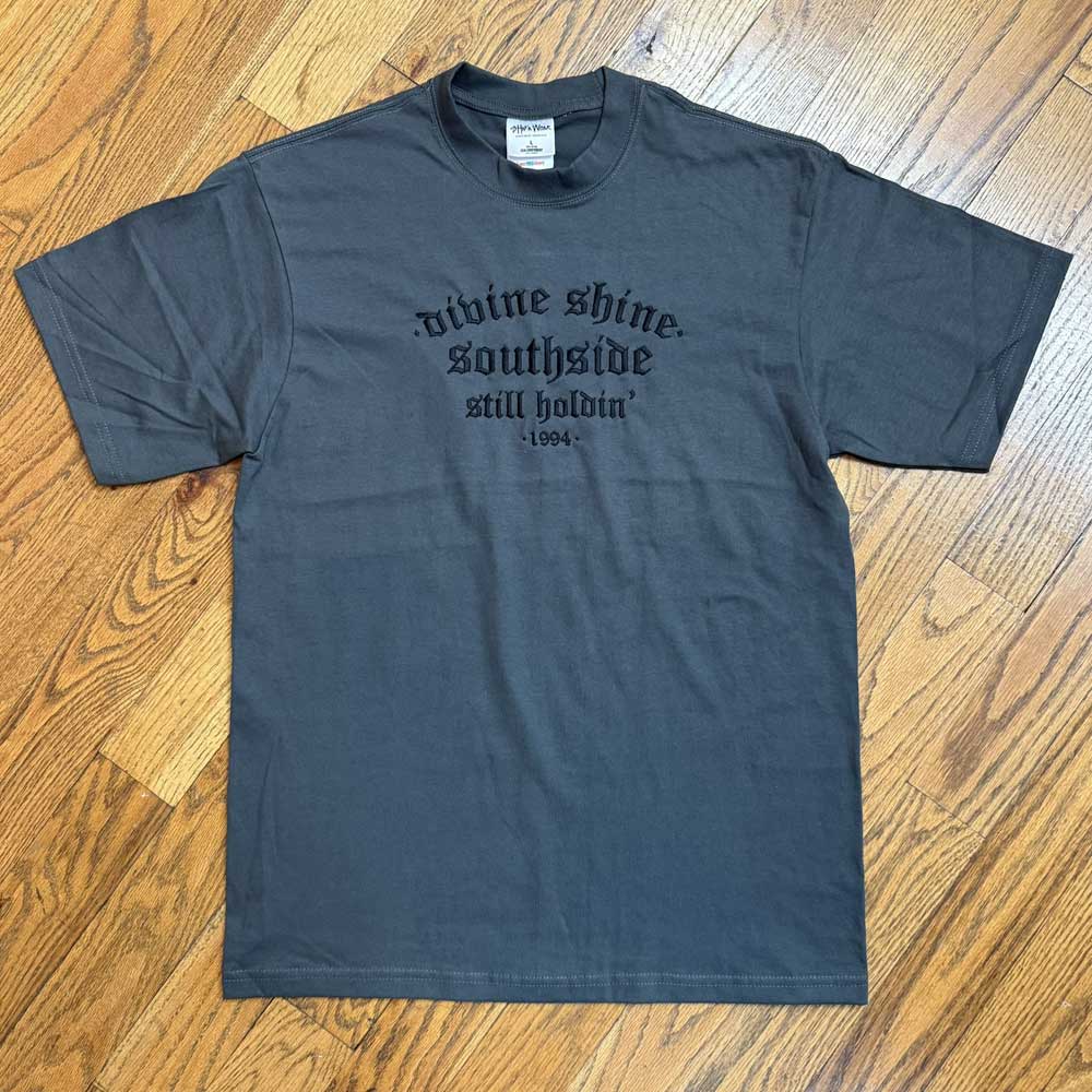The Dark Gray Divine Shine x Southside Still Holdin Max Heavyweight Tee features embroidered Southside Skatepark details, capturing streetwear vibes—ideal for fans of the iconic skatepark.