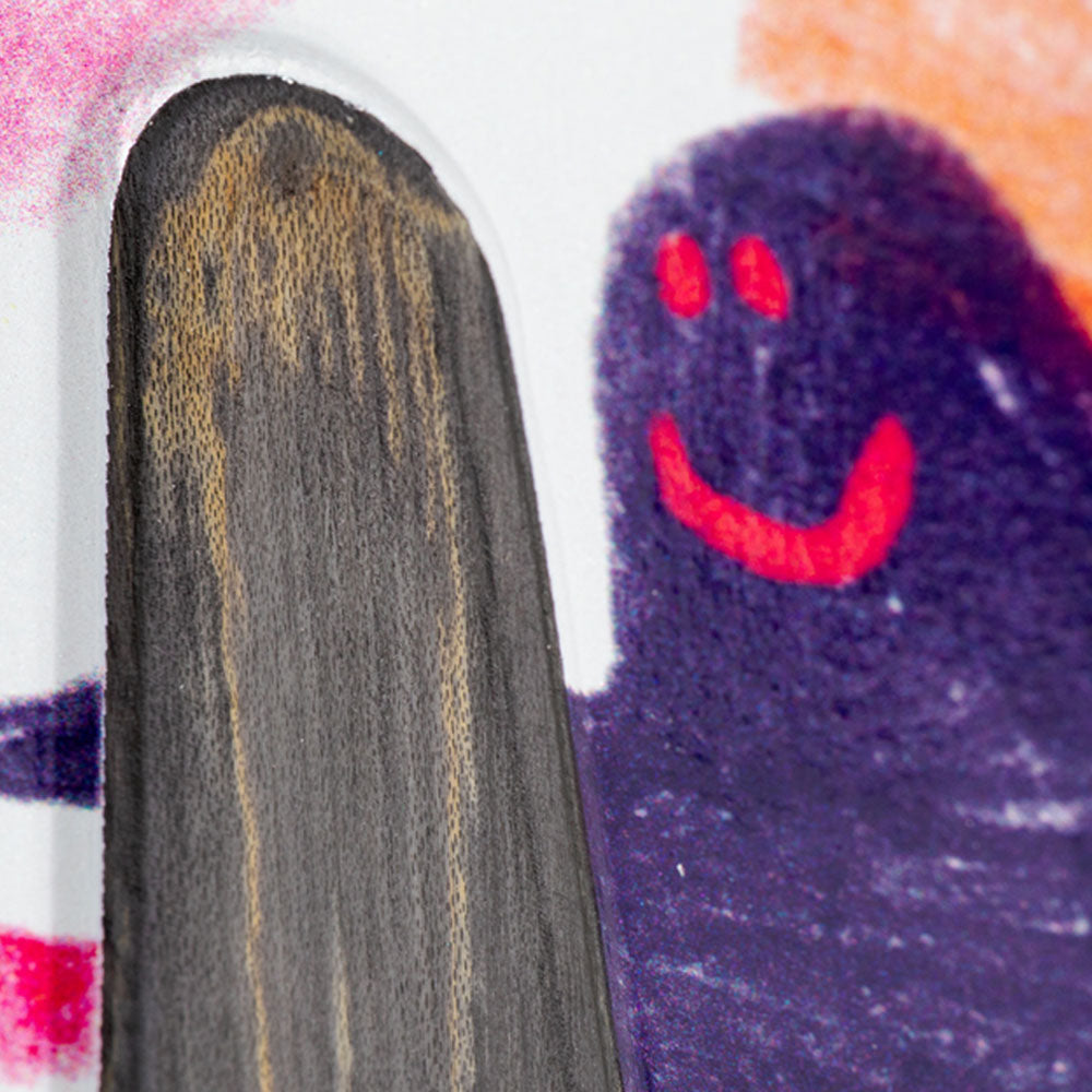 A close-up of a child’s colorful drawing shows a purple figure with a red smiling face beside a brown, wood-textured shape resembling the Diamond Quad Beemer 10.75 Krooked Deck Skateshop Day on a white background.