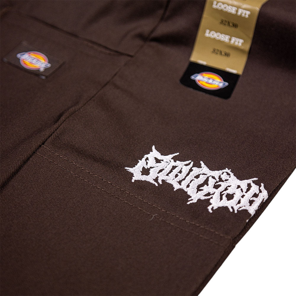 Close-up of Dark Brown Southside Texas Icon Dickies Loose Fit Double Knee Pant 85283DB with white embroidery, attached relaxed fit tags in sizes 32x30, 32x32, 32x34, and reinforced knees for durability.