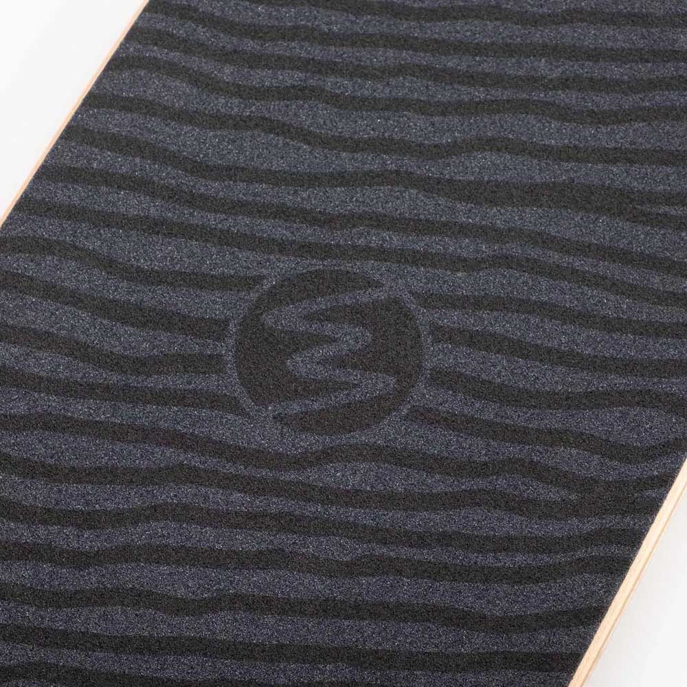Close-up of the Dinghy Classic Fender Moray Eel Landyachtz Complete Skateboard deck, featuring black grip tape with subtle wavy lines, molded wheel flares, and a circular logo with a stylized Z at the center.
