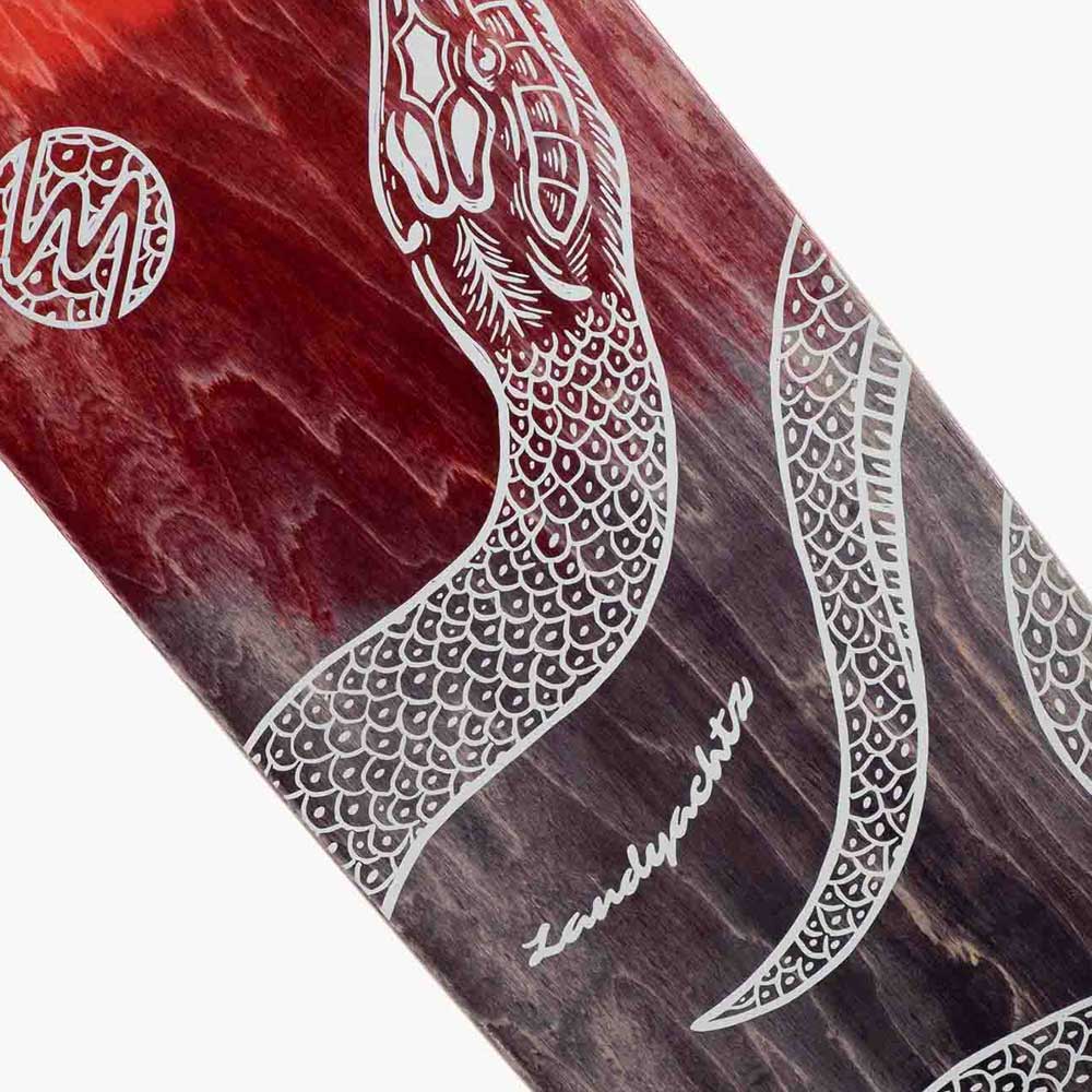 Close-up of the Drop Cat Python 38 Landyachtz Complete Skateboard deck with a red and purple wood grain background, featuring a white intricate line art snake design and "Landyachtz" in cursive.
