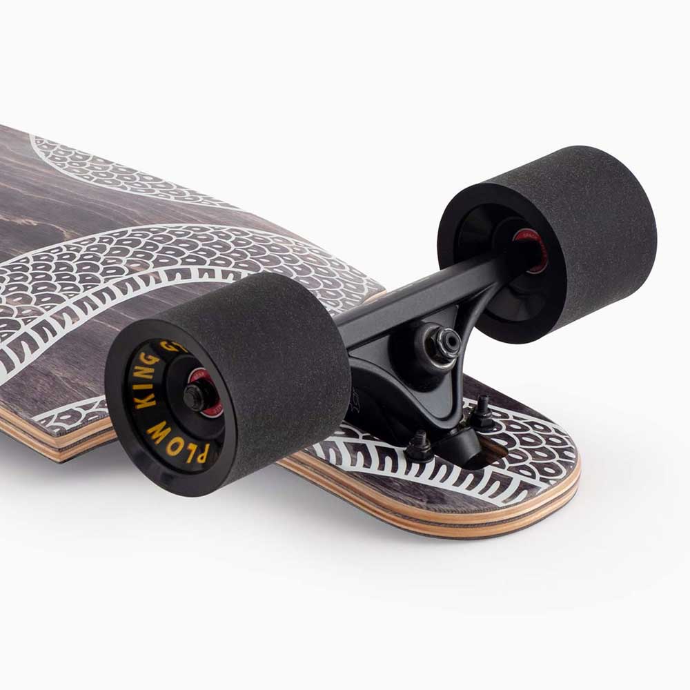 Close-up of a Drop Cat Python 38 Landyachtz Complete Skateboard with black wheels featuring yellow graphics, black trucks, and a patterned deck showcasing layered wooden edges.