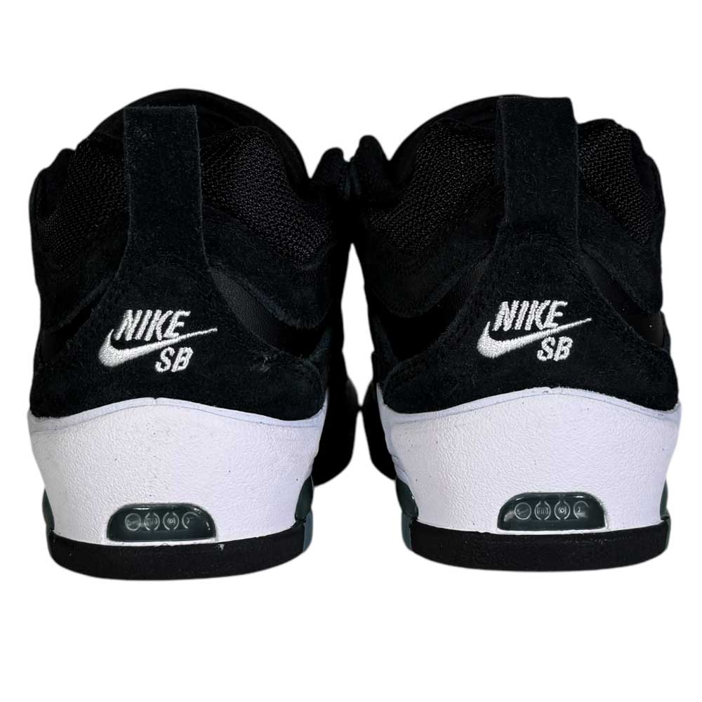 A close-up rear view of FB2393004 White Black Black Air Max Ishod Wair Leather Suede Shoes, featuring black uppers, white soles, and the Nike SB logo embroidered in white on the back of each shoe.