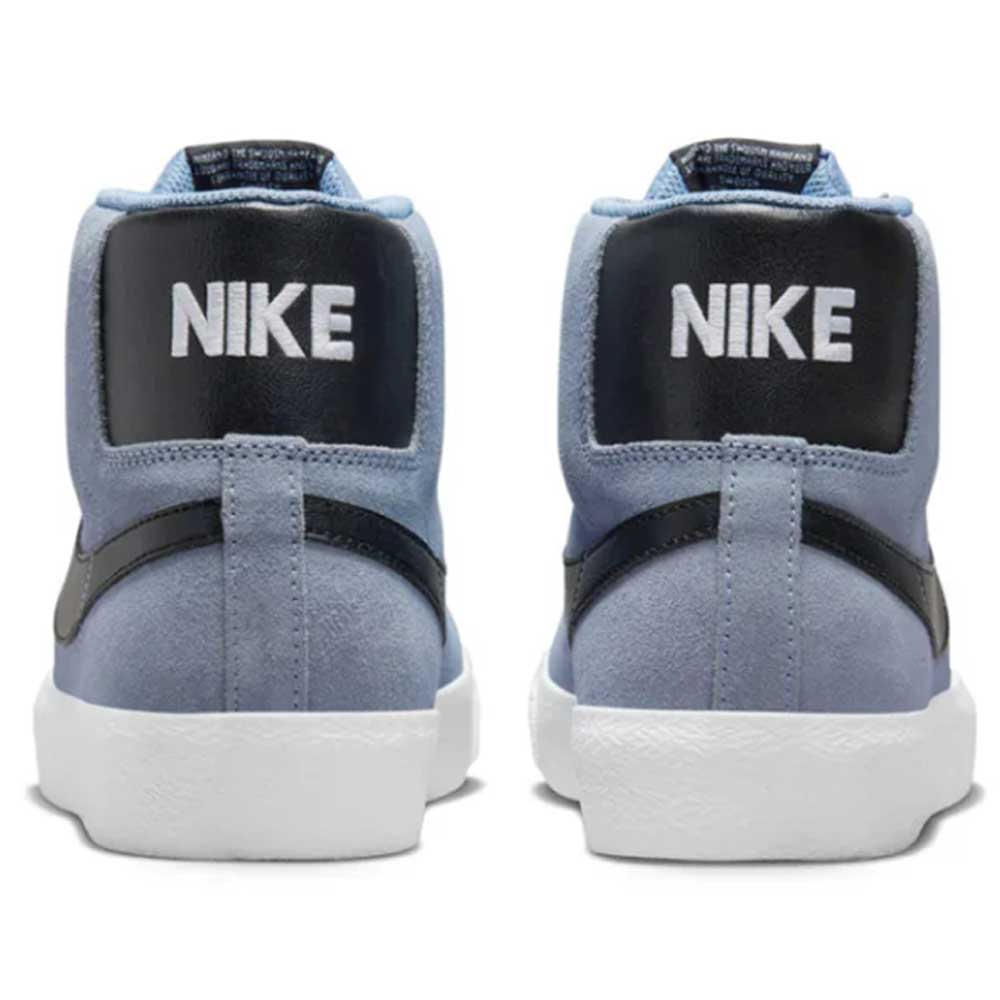 A pair of FD0731-401 Ashen Slate Blazer Mid Nike SB suede shoes viewed from the back, featuring black heel panels, bold white NIKE text, white rubber soles, and signature Zoom Air cushioning.