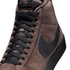Close-up of the FD0731201 Baroque Brown Black Blazer Mid Nike SB Suede Skateboarding Shoe featuring brown suede upper, black laces, black swoosh, and textured sole for responsive cushioning on a high-top skate sneaker.