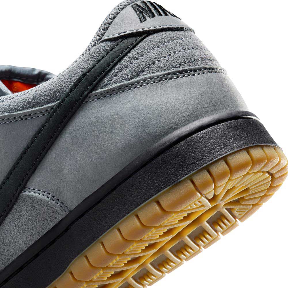 Close-up of the heel and sole of the FJ1674002 Cool Grey Black Nike SB Dunk Low Pro Suede Shoes, featuring a black stripe, gum rubber outsole, and a partially visible Nike logo—highlighting this classic sneaker.