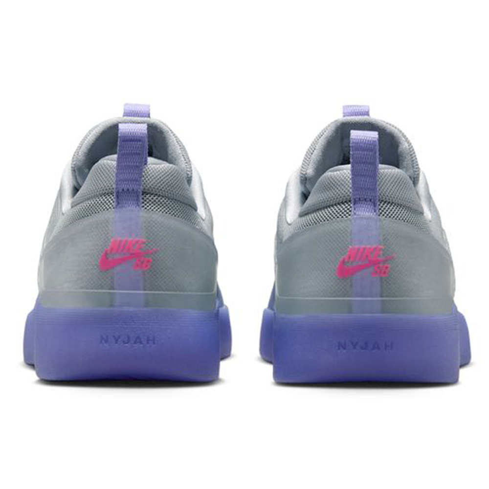 Rear view of two gray FQ1273500 Light Thistle Black Zoom Nyjah 4 Nike SB skateboarding shoes with purple soles, pink Nike SB logos on each heel, "NYJAH" on the midsoles, and a reinforced mesh upper for durability.