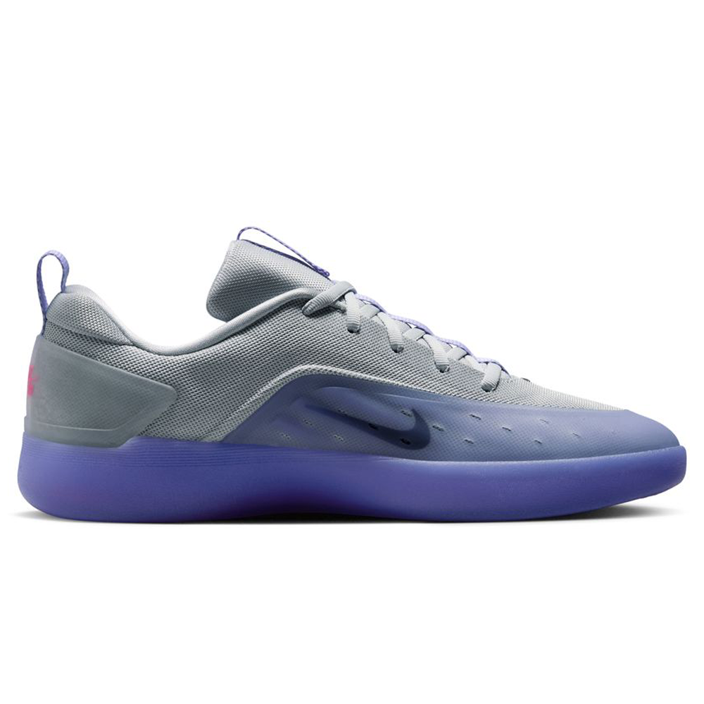 The FQ1273-500 Light Thistle Black Zoom Nyjah 4 Nike SB skateboarding shoe features a grey mesh upper, dark swoosh logo, purple sole, purple accents on the tongue and heel tab, Air Zoom cushioning, and a sleek modern design.