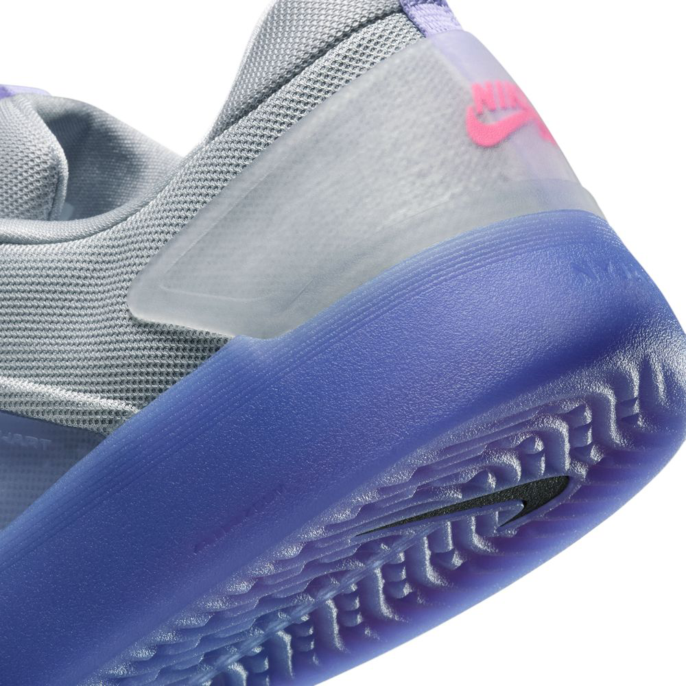 Close-up of the FQ1273500 Light Thistle Black Zoom Nyjah 4 Nike SB Skateboarding Shoe in gray, featuring a translucent heel, purple sole with grippy HART outsole, pink Nike logo, and a reinforced mesh upper for durability and breathability.