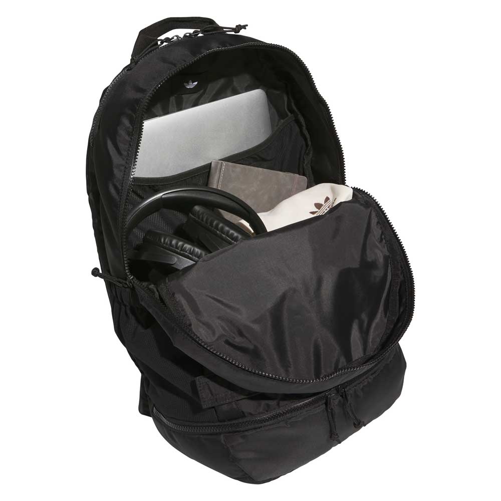 The FSBS Backpack KS6814 Black Adidas Skateboarding is shown with its main compartment open, neatly holding a laptop, notebook, headphones, and a white pouch inside—making it the perfect everyday backpack for staying organized on the go.