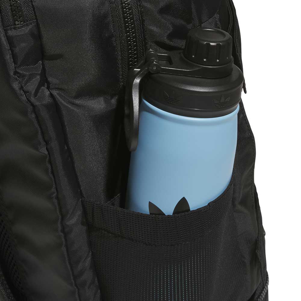 A light blue water bottle with a black lid is placed in the side mesh pocket of the FSBS Backpack KS6814 Black Adidas Skateboarding.