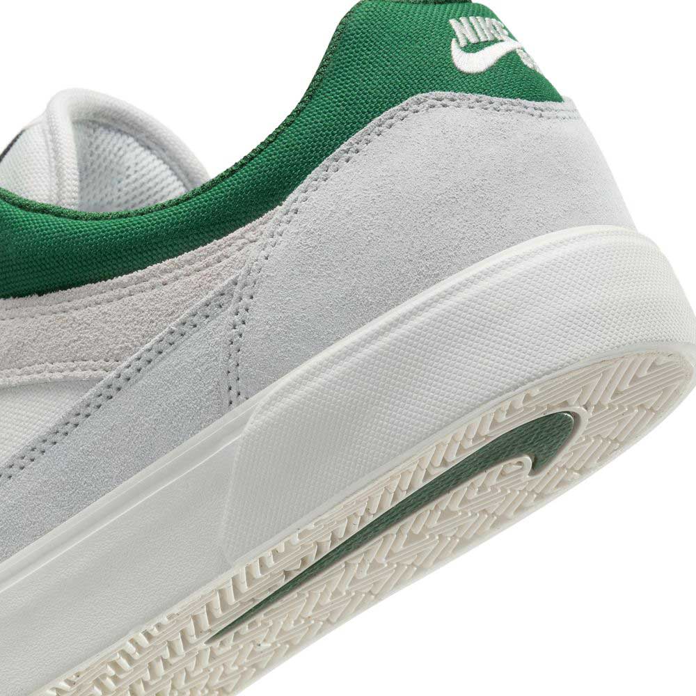 Close-up of the heel of the FV6064002 Platnium Fir Wolf Gray White Suede Nike SB Shoes, featuring a gray and white suede upper, white midsole, green heel logo, and a textured sole with a green accent.