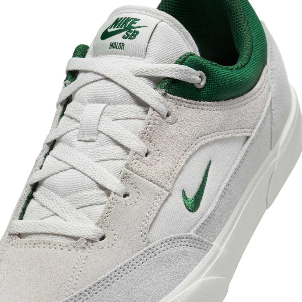 A close-up of the FV6064002 Platnium Fir Wolf Gray White Suede Nike SB Shoes featuring a white and gray suede upper, green embroidered Swoosh, green collar, white laces, and a tongue label with green Nike SB branding.