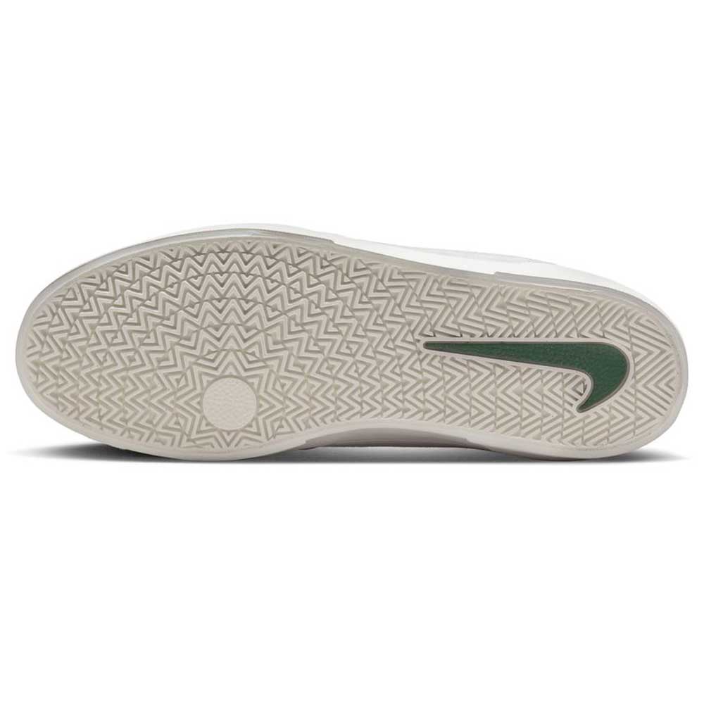 The image shows the sole of a white Nike SB FV6064002 Platinum Fir Wolf Gray skate shoe, featuring a geometric tread pattern for grip and traction. The durable suede construction is perfect for skateboarding.