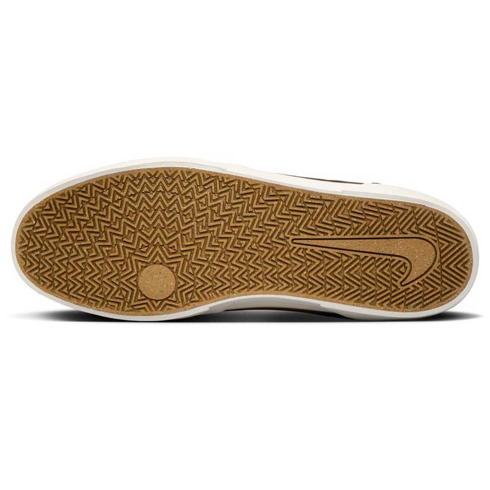 The image shows the sole of the FV6064005 Ironstone Light Khaki Malor Nike SB Suede Skateboarding Shoe, with a brown rubber base, herringbone tread for grip, a white border around the edge, and a large swoosh on the right.