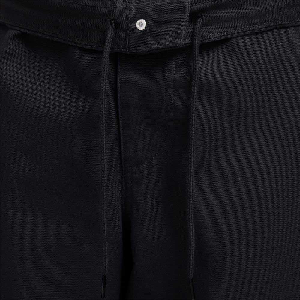 Close-up of the waistband on the FV7349010 Double Knee Pant Black Nike SB Skateboarding, featuring black cotton twill fabric, a drawstring tie, and a small silver button at the top center.