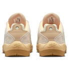 A pair of FZ4878-100 Summit Coconut Milk Jade Ice Sesame Vertebrae Nike SB suede shoes seen from the back, featuring suede uppers, textured outsoles, and embossed Nike SB logos on the heels.