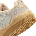 Close-up of the heel and side of a FZ4878100 Summit Coconut Milk Jade Ice Sesame Vertebrae Nike SB Suede Shoe, featuring a textured sole, light stitching, and embossed Nike SB with a circular logo on suede and rubber materials.